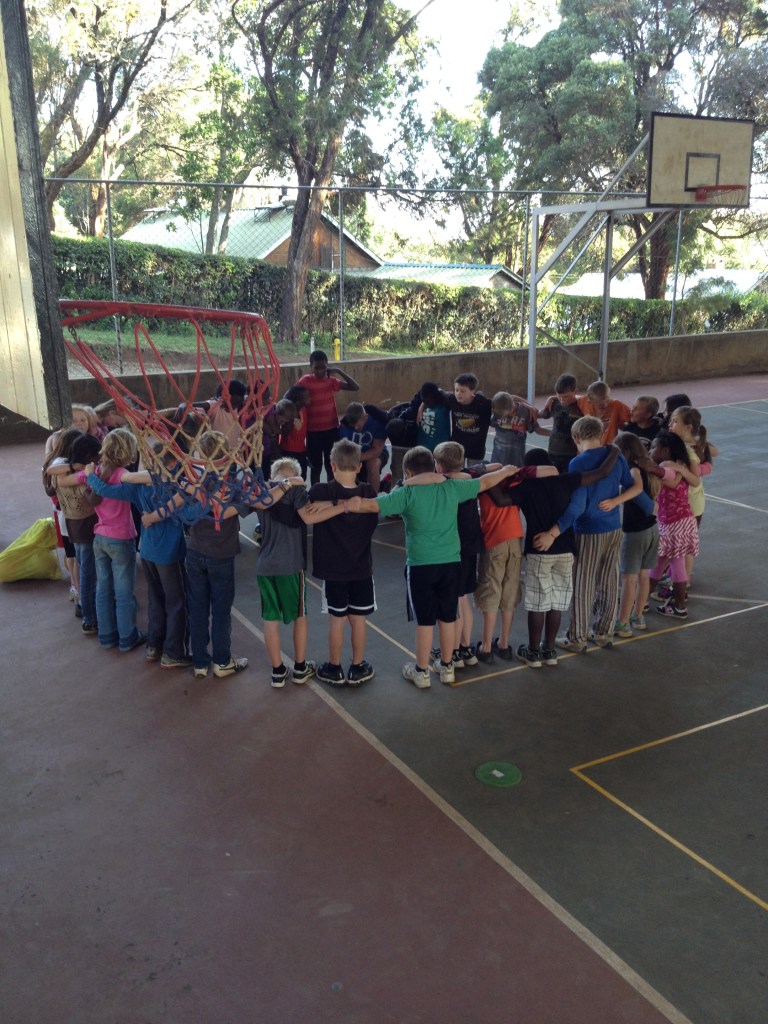 Third and fourth graders praying together after an afternoon of basketball playing and instruction
